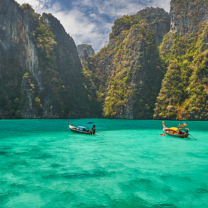 Turquoise water with boats and cliffs in Thailand